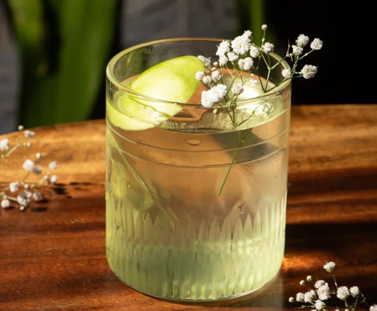 Garnished cocktail on a wooden table at Makau